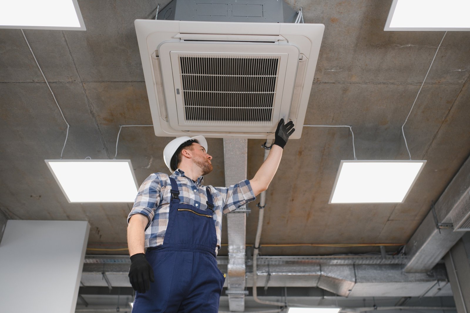 Hvac technician installing air conditioning unit in building